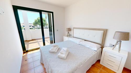 Un dormitorio con una cama con dos toallas encima. en Amapola, en L'Ampolla