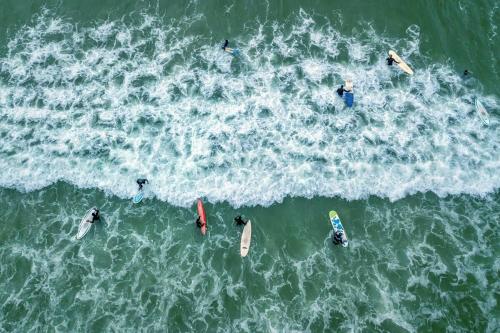 a group of people in the water in the ocean at Annies Place Muizenberg in Muizenberg