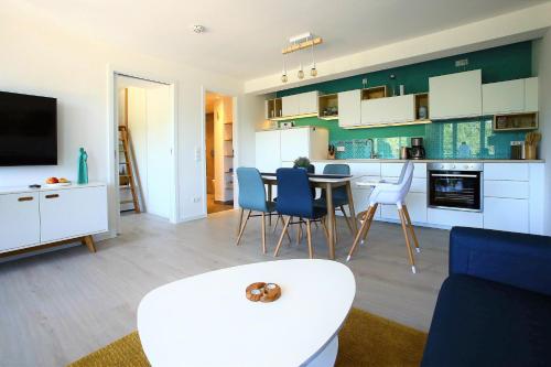 uma cozinha e sala de estar com mesa e cadeiras em FeWo Prora - room-of-light em Binz