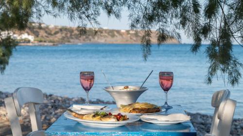 a table with food and two glasses of wine at Minoa sea rooms in Tsoútsouros