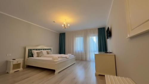 una camera da letto con un letto bianco e una finestra di Perla Dacilor a Grădiştea de Munte