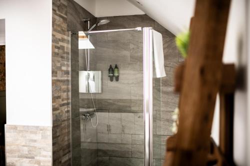a shower with a glass door in a bathroom at Stonehenge Courtyard in Amesbury