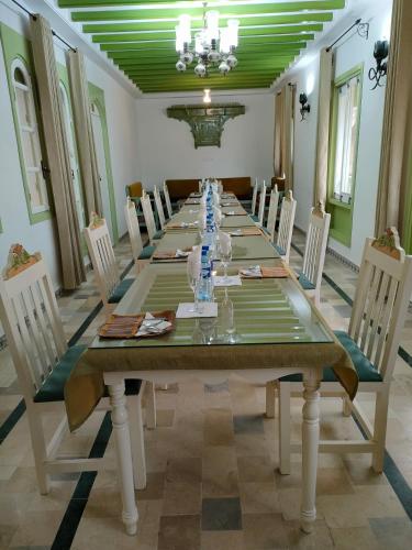a dining room with a long table and chairs at Dar lella habiba in Kairouan
