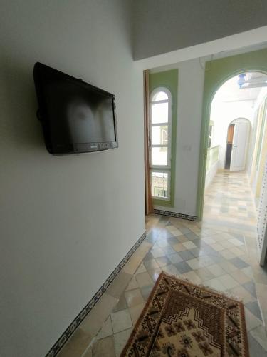 a flat screen tv on a wall in a room at Dar lella habiba in Kairouan