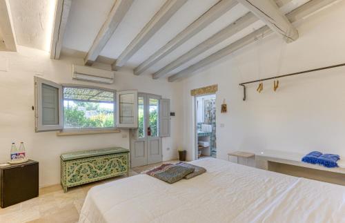 1 dormitorio con cama blanca y ventana en BioMasseria Santa Lucia en Alessano