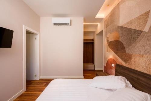 a bedroom with a bed and a painting on the wall at Tripolina Camere in Ladispoli