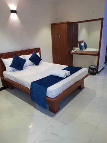 a bedroom with a large bed with blue pillows at StarNexa Residency in Navi Mumbai
