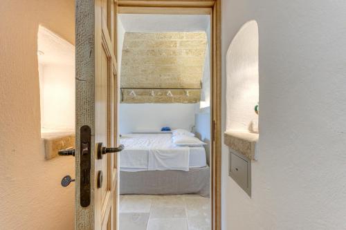 Una puerta que conduce a un dormitorio con cama en BioMasseria Santa Lucia en Alessano