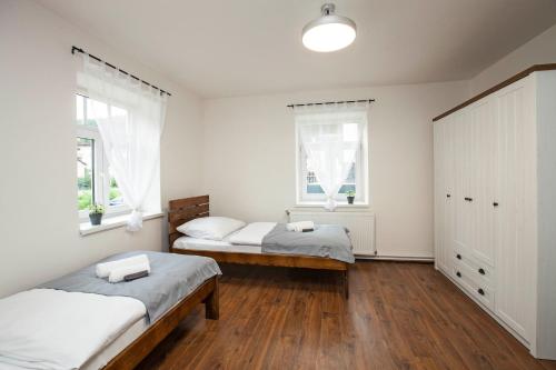 two beds in a room with two windows at Apartmány Vilka Orlík in Teplice nad Metují