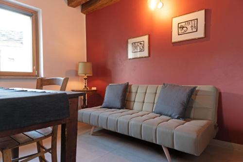 a living room with a couch against a red wall at Cicapuy in Puys