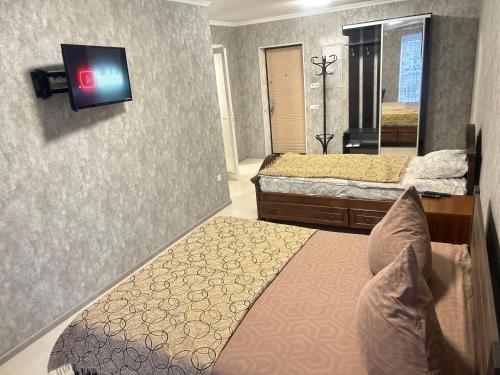 1 dormitorio con 2 camas y TV en la pared en Готель-ГАЙСИН-Ресторан en Haysyn