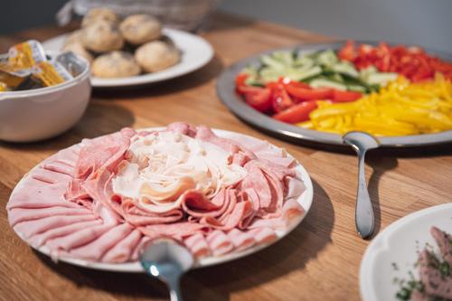 a table with plates of food and plates of vegetables at Apartmány Vilka Orlík in Teplice nad Metují
