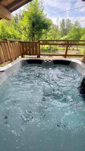 une piscine d'eau dans une arrière-cour avec une clôture en bois dans l'établissement La cabane à sucre, à Raon-aux-Bois