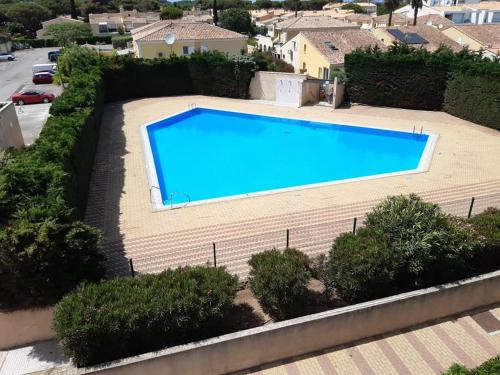 - une vue sur la grande piscine bleue dans l'établissement Village naturiste - Port-Vénus - Villa les pieds dans l'eau, au Cap d'Agde