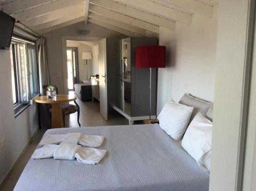 a bedroom with a bed with two towels on it at Ktima Faki, Olympus Mountain Accommodation & Retreat in Litochoro