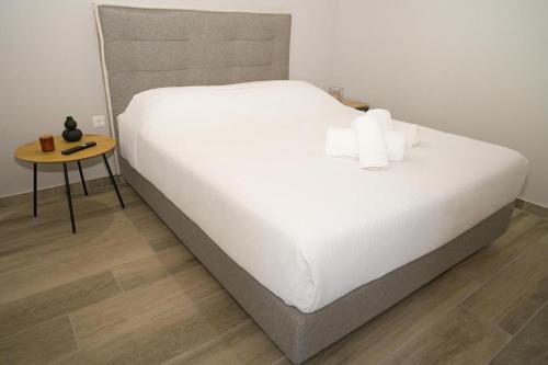 a large bed with white sheets and a side table at Ktima Faki, Olympus Mountain Accommodation & Retreat in Litochoro