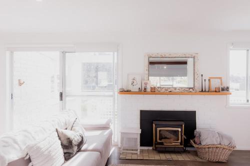 a living room with a couch and a fireplace at Riverside Retreat in Orford in Orford