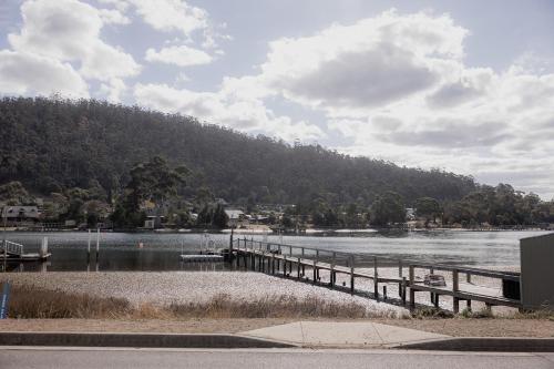 a dock on a lake with a mountain in the background at Riverside Retreat in Orford in Orford