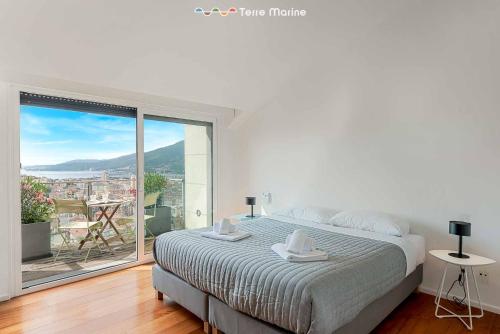 a white bedroom with a bed and a large window at Bay View Home, TerreMarine in La Spezia