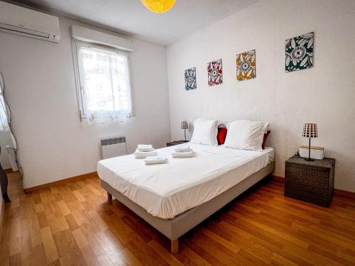 une chambre avec un grand lit blanc dans une pièce dans l'établissement Lucia - Proche mer, Balcon, Clim - by TGB, à Ajaccio