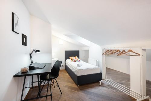 a bedroom with a bed and a desk and a desk at Rehorova apartments in Prague