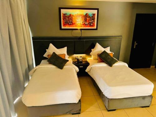 two beds in a hotel room with white sheets at O Beach Hotel & Resort in Sowayma