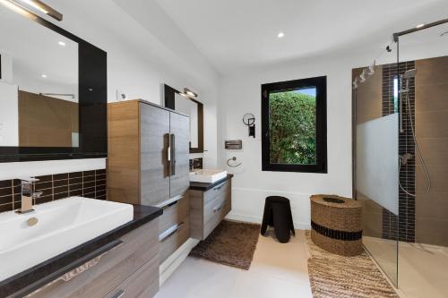 une salle de bain avec une baignoire, un lavabo et une douche dans l'établissement Villa Grande Vue, aux Issambres