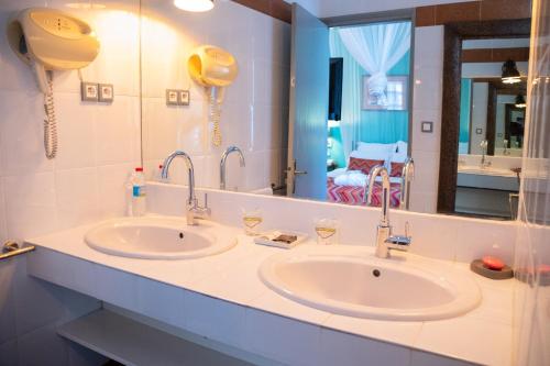 a bathroom with two sinks and a large mirror at La Varangue in Antananarivo