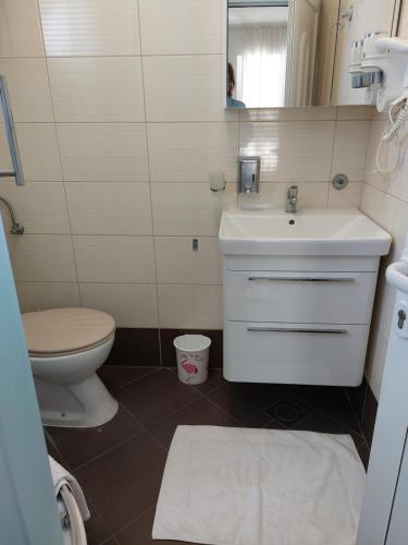 a bathroom with a sink and a toilet and a mirror at Villa Espero in Trogir