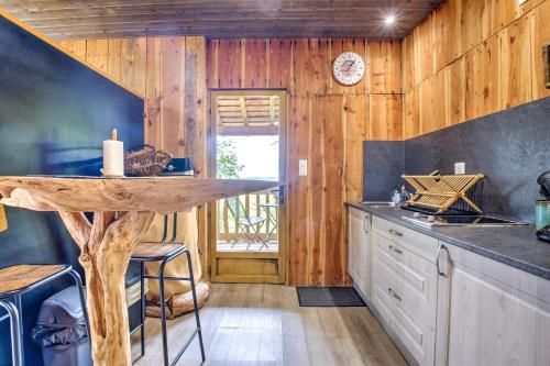 une cuisine avec des murs en bois et un comptoir avec une table dans l'établissement La cabane de Gardelac, à Saint-Rémy