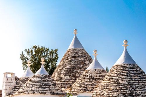 un gruppo di tetti a punta di un edificio di Golden Hill Trulli with Pool - large garden for furry friends a Ceglie Messapica