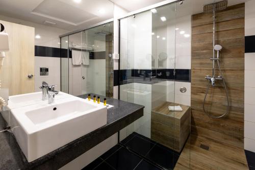 a bathroom with a sink and a shower at Grand Hotel Riga in Ruse
