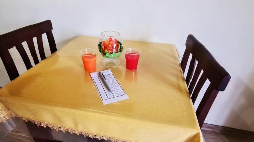 une table jaune avec deux verres et un vase de fleurs dans l'établissement Camera matrimoniale 1 per vacanza al mare VILLA FRANCA, à Cariati