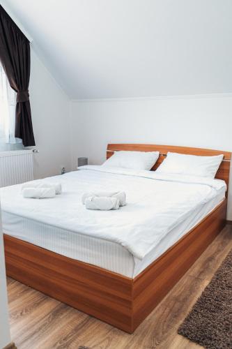 a bedroom with a large bed with two towels on it at Pensiunea Kacsó in Măgherani