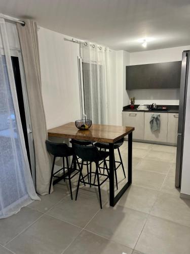 une cuisine avec une table et des chaises dans une pièce dans l'établissement T3 neuf Porticcio centre, à Porticcio