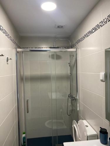 a bathroom with a glass shower with a toilet at Cotovia Lodge in Sesimbra