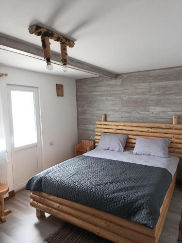 a bedroom with a wooden bed with a wooden headboard at Casa Vanatorului Buzaiel in Vama Buzăului