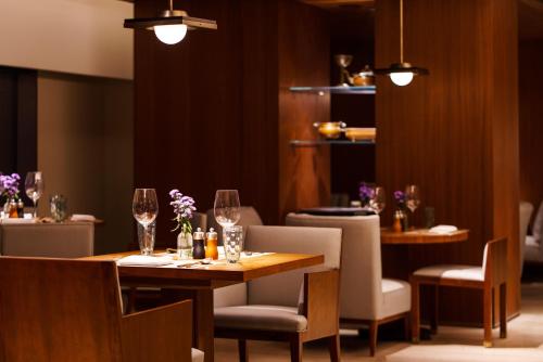 a restaurant with two tables and chairs with wine glasses at Maxx by Steigenberger on the Bund Shanghai in Shanghai