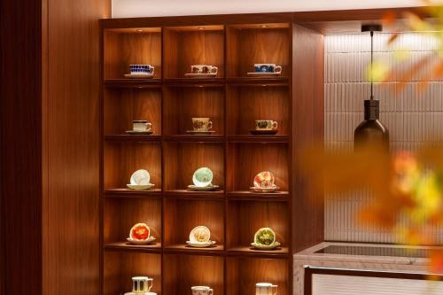 a wooden shelf with plates on it at Maxx by Steigenberger on the Bund Shanghai in Shanghai