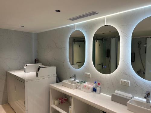 a bathroom with two sinks and two mirrors at Twin Star Inn in Taipei