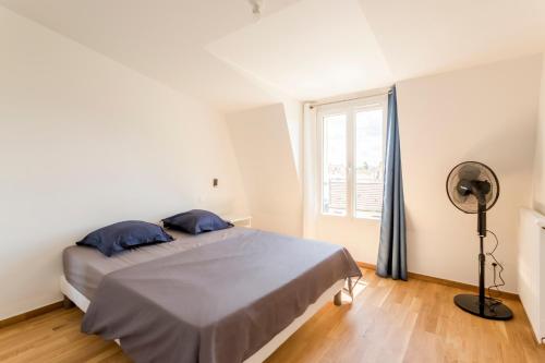- une chambre avec un lit, une fenêtre et un ventilateur dans l'établissement Appartement moderne proximité de Paris avec Parking, à Choisy-le-Roi