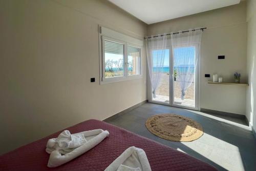 a bedroom with a bed with a view of the ocean at Lambou Beach Sunset in Soroni