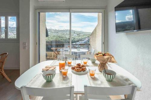 - une table blanche avec de la nourriture et des boissons dans l'établissement Duplex dans résidence avec piscine, à Porticcio