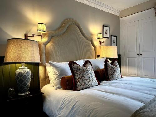 a bedroom with a large white bed with two lamps at Worlington Hall in Worlington