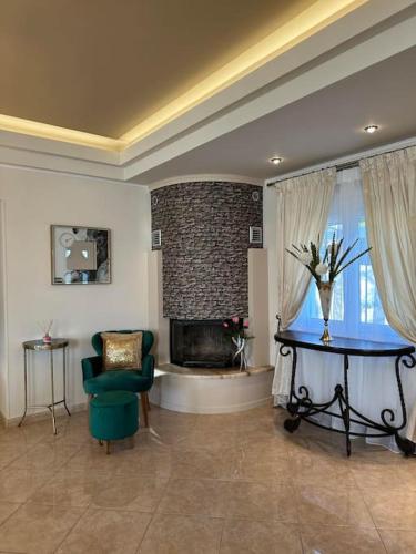 a living room with a fireplace and a green chair at Altera Vita in Agía Zóni
