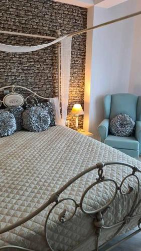a bedroom with a bed and a blue chair at Altera Vita in Agía Zóni