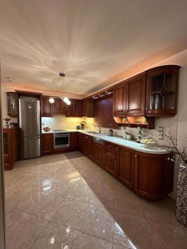 a large kitchen with wooden cabinets and a refrigerator at Altera Vita in Agía Zóni