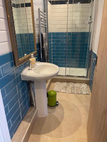 a bathroom with a sink and a shower at Love St Leonards Flat in St. Leonards