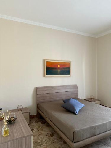 a bedroom with a bed and a painting on the wall at Appartamento Sea La Vie in Custonaci
