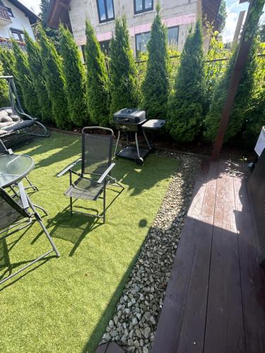 a backyard with chairs and a grill on the grass at Jagoda in Brenna